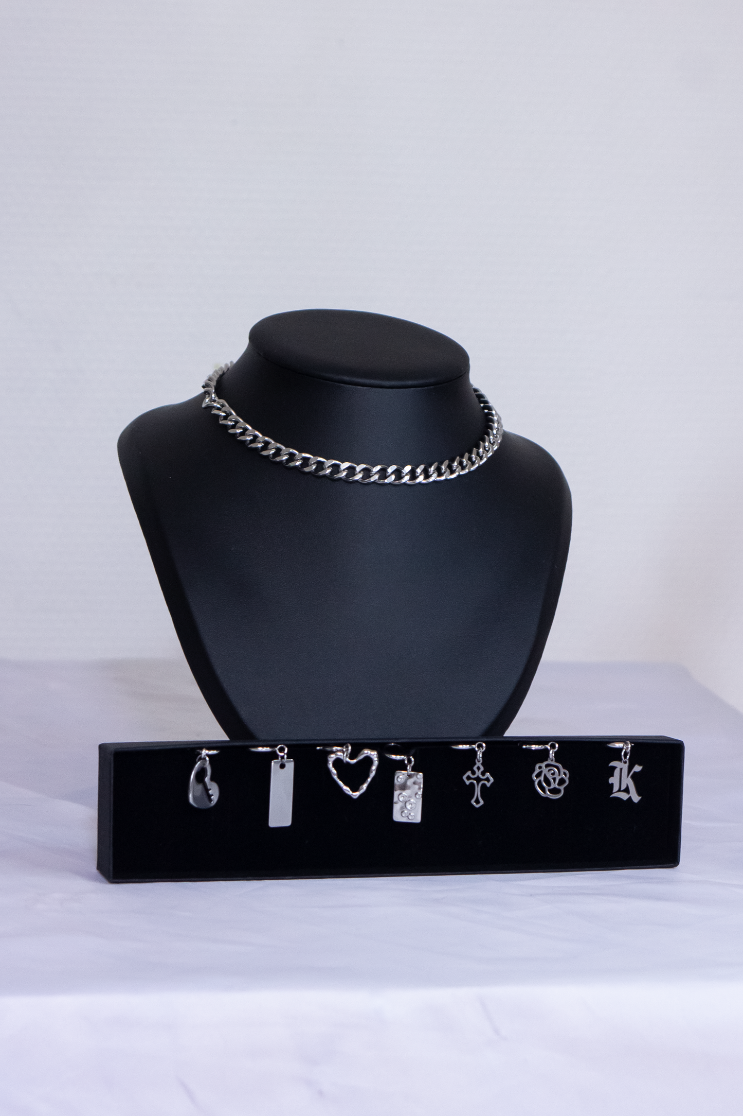 Différents pendentifs argentés et gothiques, croix, rose, coeur